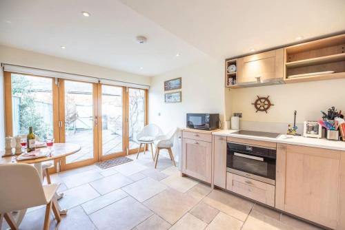 a large kitchen with a table and a dining room at Pebbles Cottage, Southwold in Southwold