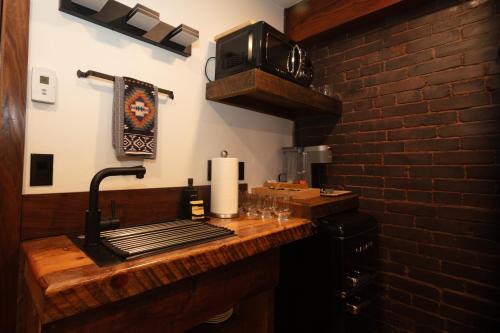 a kitchen with a counter top with a brick wall at The Frenchman Suites in Silverton