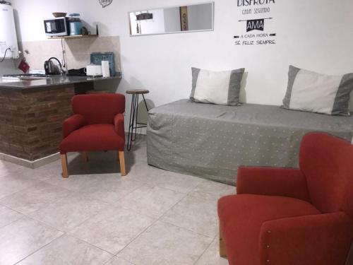 1 dormitorio con 1 cama, 2 sillas y barra en Departamento Libertad en Puerto Madryn
