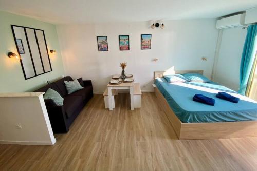a small bedroom with a bed and a couch at Grands studio en bord de mer in Cagnes-sur-Mer