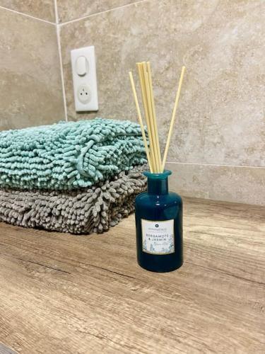 - un pot bleu avec des bâtons de bambou à côté d'une salle de bains dans l'établissement Grands studio en bord de mer, à Cagnes-sur-Mer