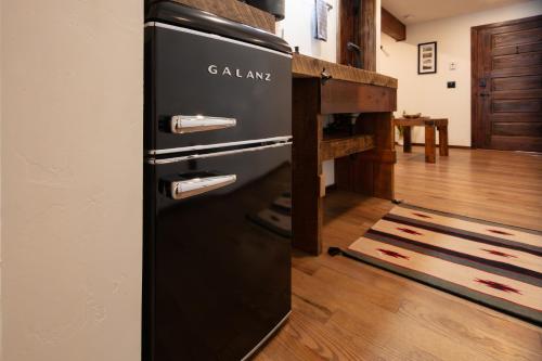 a black refrigerator in a room with a wooden floor at The Frenchman Suites in Silverton
