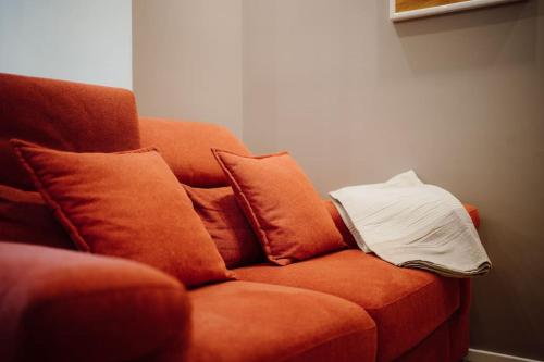 an orange couch with pillows on it in a room at ARTpartment - 2 camere - WiFi - Garage in Vallecrosia