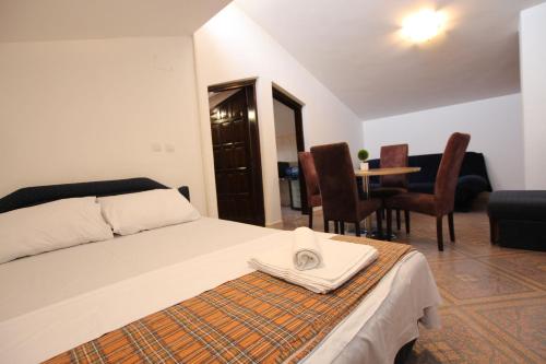 um quarto com uma cama, uma mesa e cadeiras em Magnolia rooms and apartments em Sutomore