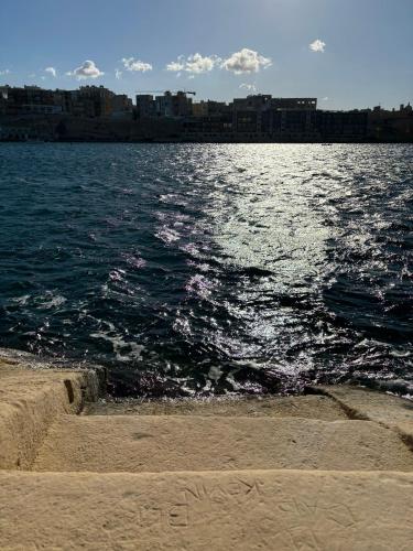 a view of a body of water from the beach at Traditional Maltese Sea View Apartment in Kalkara