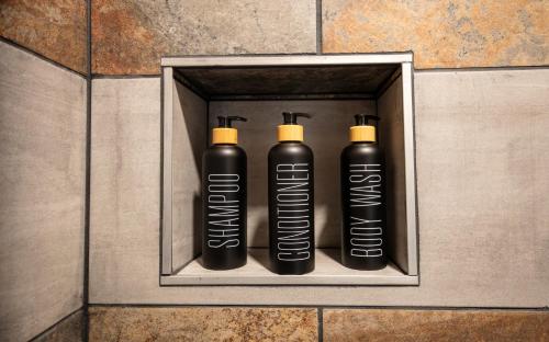 three black bottles in a metal box on a wall at The Frenchman Suites in Silverton