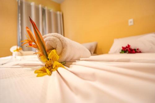 um quarto de hotel com duas camas com toalhas e flores em Pousada Morro do Caburé em Cajueiro