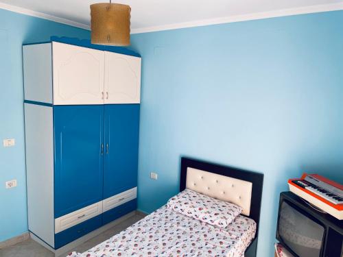 Empire Apartments في برميت: غرفة زرقاء مع سرير وخزانة