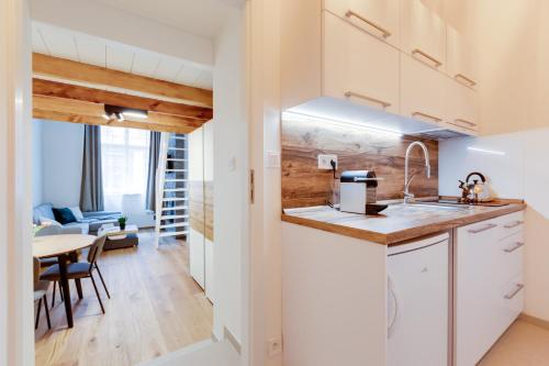 a kitchen with white cabinets and a dining room at Dream Apartments Prague in Prague