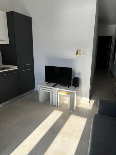 a living room with a tv on a white wall at Traditional Maltese Sea View Apartment in Kalkara