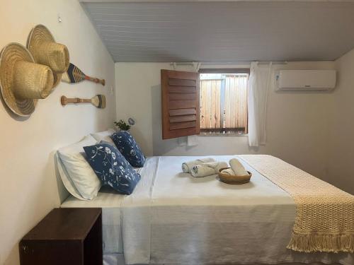 a bedroom with a large bed with blue pillows and a window at Malai Beach in Jericoacoara