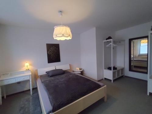 a bedroom with a bed and a desk and a lamp at Ferienwohnung Flüburg in Diemelstadt 