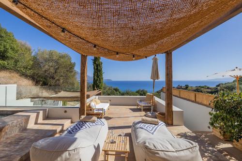 eine Terrasse mit Gartenmöbeln und Meerblick in der Unterkunft Eliamos Villas Hotel & Spa in Sparta