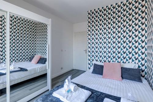 a bedroom with two beds and a mirror at 803 Suite Parisian - Superbe appartement in Bagnolet