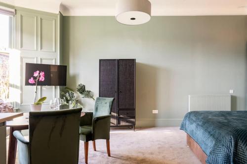 a bedroom with a bed and a desk and a table at Boutique Home Stay - Bliss Studio in Paisley