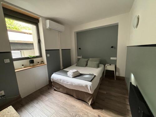 a small bedroom with a bed and a window at Casa Hotel in Aix-en-Provence