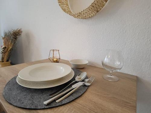 a wooden table with a plate and a glass at Studio-Priv.Parkplatz-Balkon-Wlan-Netflix-SmartTV in Deizisau