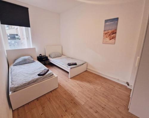 een slaapkamer met twee bedden en een raam bij City Apartment in Bremerhaven