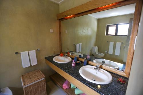 a bathroom with two sinks and a large mirror at Villa Voilier in Mahe