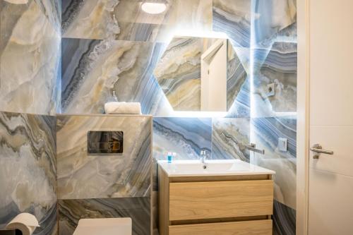 a bathroom with a sink and a mirror at Etti - Paradise Suite La Roca in La Lajita