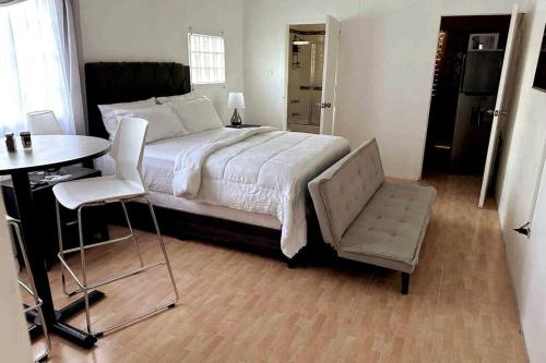 a bedroom with a bed and a table and a chair at Eagles Nest Villa Studio AC TV WIFI Fan Luxury Modern in Albion