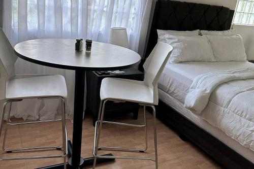 a table and two chairs next to a bed at Eagles Nest Villa Studio AC TV WIFI Fan Luxury Modern in Albion