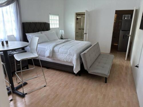 1 dormitorio con 1 cama, 1 mesa y 1 silla en Eagles Nest Villa Studio AC TV WIFI Fan Luxury Modern, en Albion