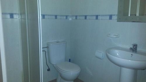 a white bathroom with a toilet and a sink at Apartamento Ático Select Real Caldas de Reis in Caldas de Reis