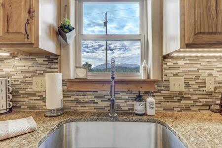 une cuisine avec un évier et une fenêtre dans l'établissement Cabin~Views~Heart of Town~W&D~Fireplace~Kitchen, à Woodland Park