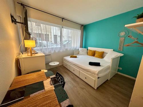 - une chambre avec un lit blanc et un mur bleu dans l'établissement Studio - Centre - Top Destination Sud Ouest, à Dax