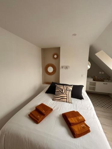 een slaapkamer met een wit bed met twee zakken erop bij Rance Solidor in Saint-Malo