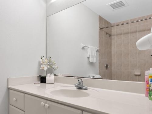 baño con lavabo y espejo grande en South River Suites, en Medley