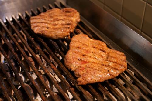 Drei Hamburger kochen auf einem Grill in der Unterkunft Alte Winzerschenke in Bruttig-Fankel