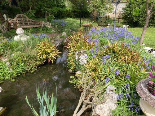 a garden with a pond and flowers and a bench at La Gueriniere l'anglaise in Châteauneuf-sur-Charente