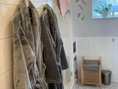 a bunch of towels hanging on a rack in a bathroom at Bed & Breakfast - appartement d'Ambacht in Borger