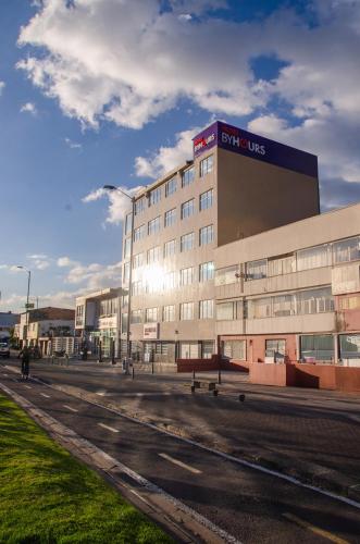 a large building with a bench in front of it at Hotel ByHours Las Américas in Bogotá
