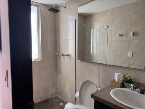 a bathroom with a shower and a toilet and a sink at Acogedor apartamento cerca a Unicentro in Bogotá