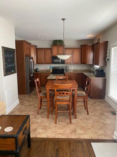 a kitchen with a wooden table and chairs and a table and a kitchen with at Davidson House - 3 beds 2.5 baths in Davidson