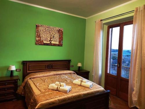 een groene slaapkamer met een bed met twee handdoeken erop bij Casa Bibi-Montepulciano-5 posti in Montepulciano