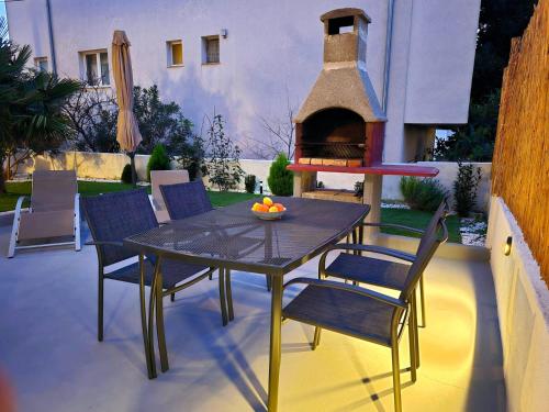 a patio with a table and chairs and a pizza oven at Apartmani Krnić in Šibenik