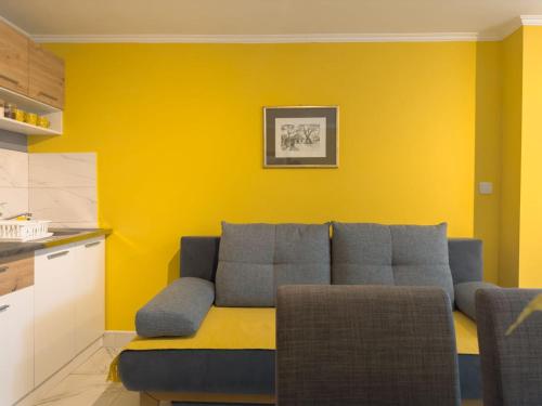 a living room with a couch and a yellow wall at HILL 2 in Golubac