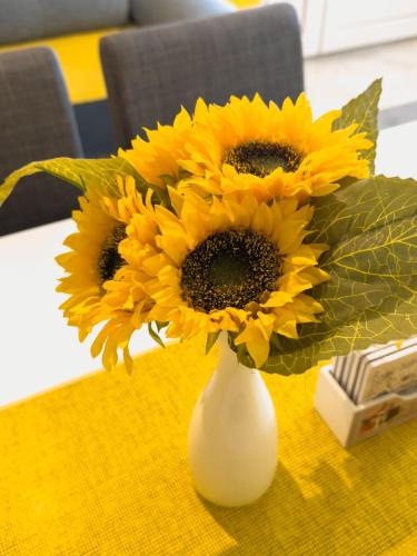 a vase filled with yellow sunflowers on a table at HILL 2 in Golubac
