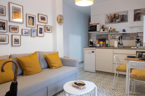 een woonkamer met een bank en een keuken bij Apartamentos San Francisco in Sevilla