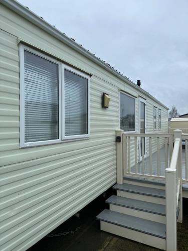a mobile home with a staircase and windows at Tattershall lakes in Tattershall