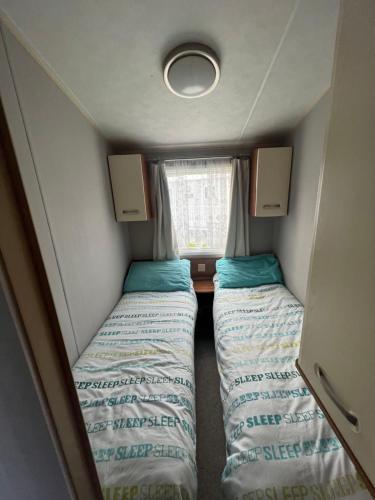 a small room with two beds and a window at Tattershall lakes in Tattershall