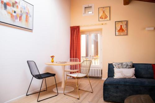 ein Wohnzimmer mit einem Tisch, Stühlen und einem Sofa in der Unterkunft La Sorpresa - luxury apartment in historic city center in Arona