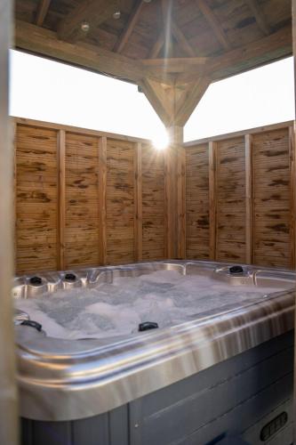 Cette chambre dispose de murs en bois et d'un grand bain à remous. dans l'établissement Omaha gîtes, à Vierville-sur-Mer