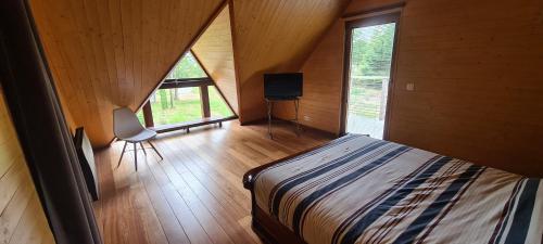 ein Schlafzimmer mit einem Bett in einem Holzhaus in der Unterkunft L'atelier in Soucelles