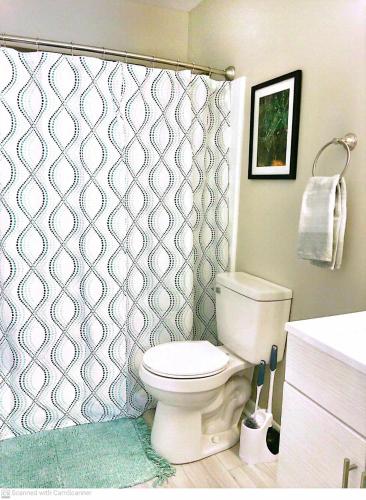 a bathroom with a toilet and a shower curtain at Liberty Towne Spring Lake - Premium WiFi Near I-95 & Fort Bragg - Perfect for short or long-term stays in Fayetteville