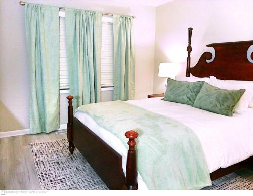 1 dormitorio con 1 cama grande y cabecero de madera en Liberty Towne, en Fayetteville